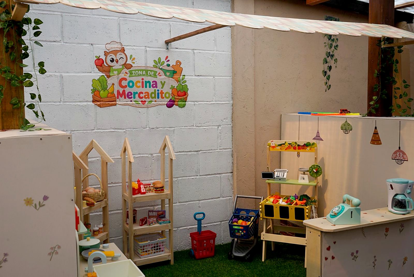Zona de juego con cocinita de madera y puesto de mercado