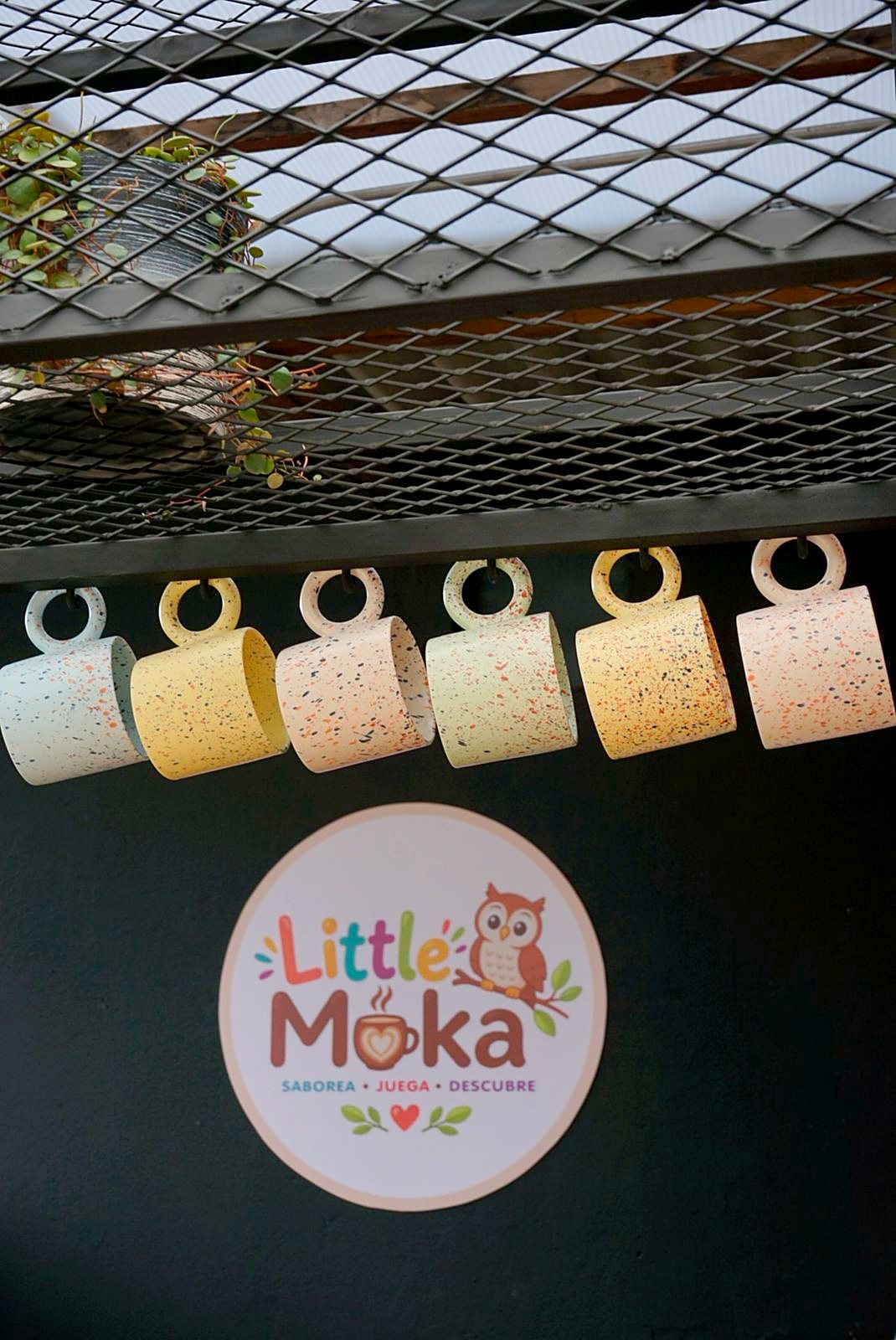 Tazas colgadas junto al logo de Little Moka