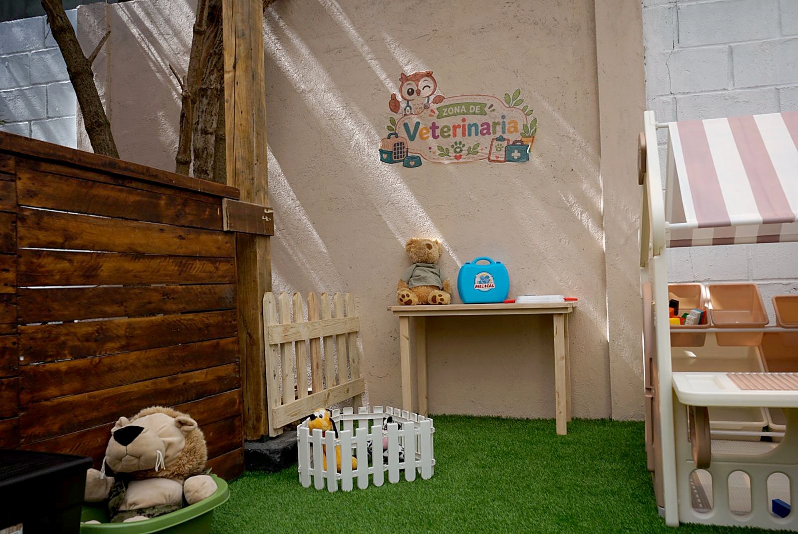 Rincón de juego de veterinaria, con peluches y camilla