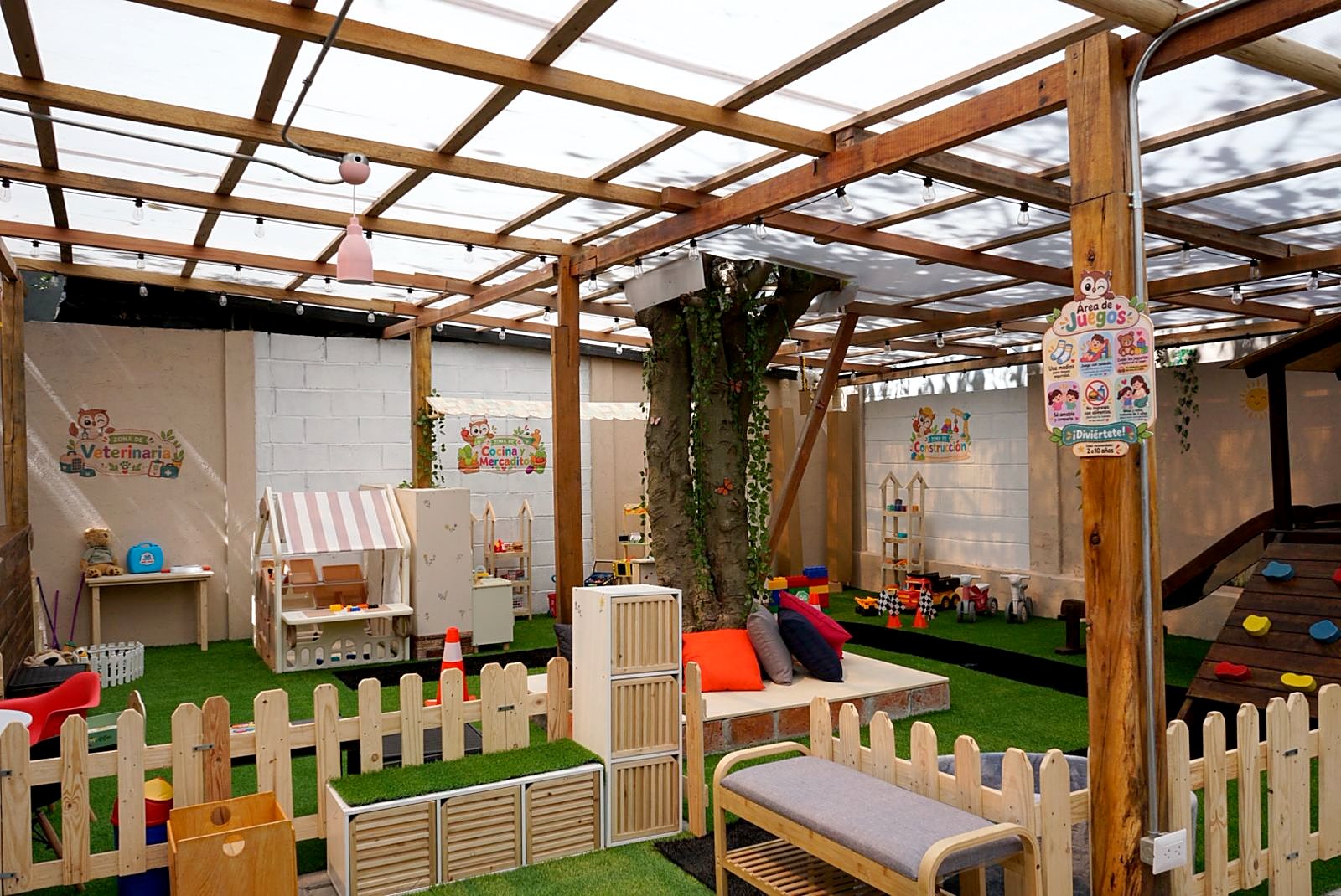 La zona de juegos de Little Moka, techada, con casitas de juego y césped